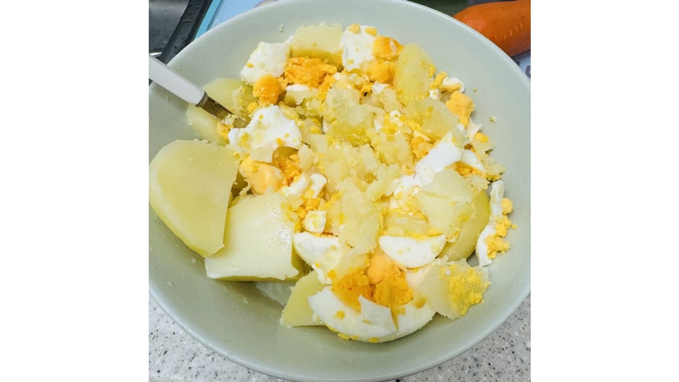 Pommes de terre et œufs en train d'être écrasés ensemble