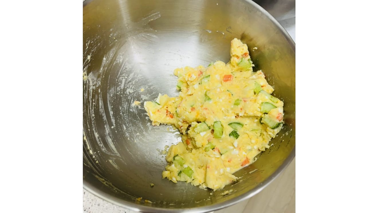 Mixing mashed potatoes with cucumber and carrots