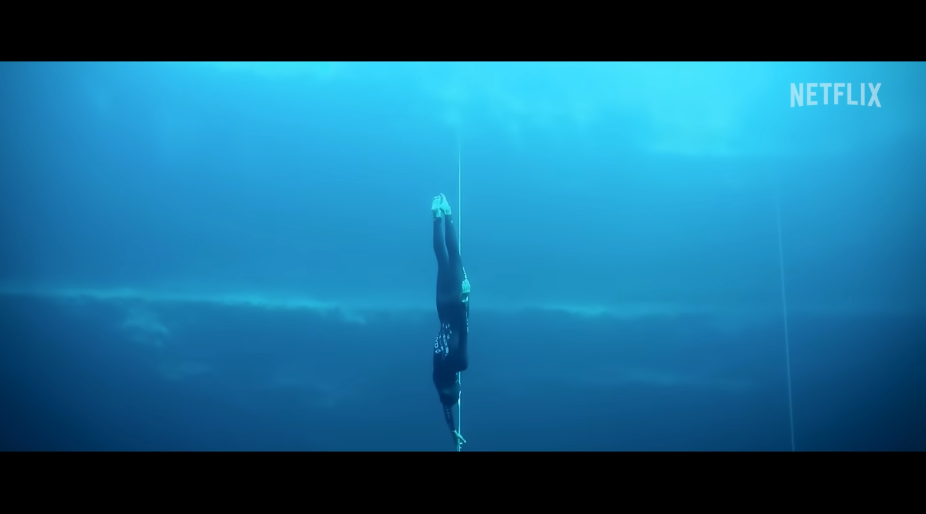 Una mujer entrando al agua bajo el mar