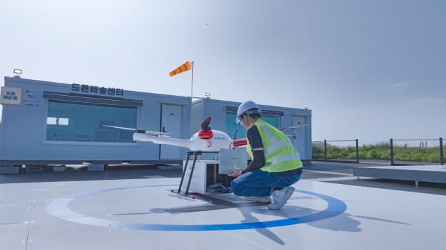 Uma pessoa operando um drone no centro de entrega de drones