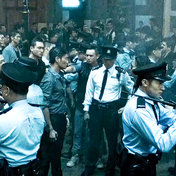 Hình ảnh một nhóm người đàn ông và cảnh sát đối đầu với nhau