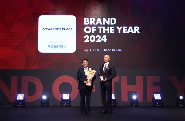 Tous Les Jours receiving the 2024 Brand of the Year Award. Two men are standing.