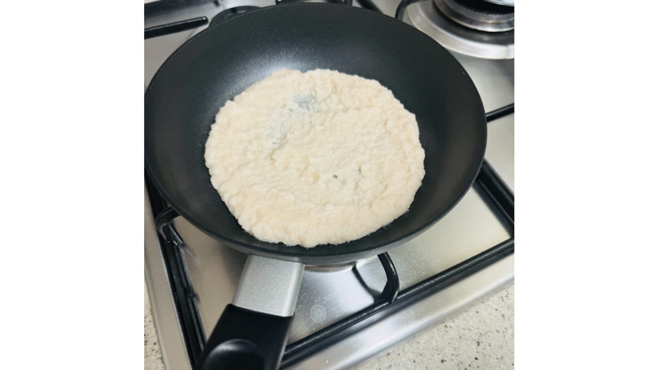 A batata ralada sendo colocada na frigideira
