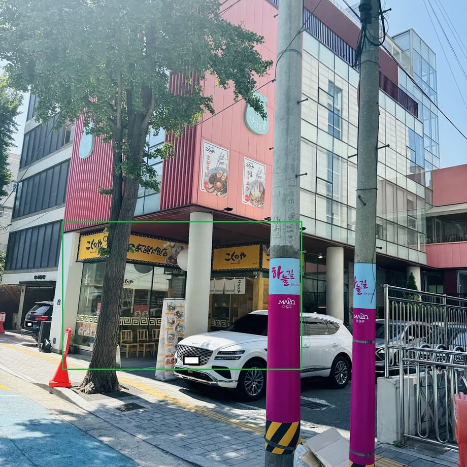 A view of buildings and vehicles in Hapjeong-dong