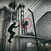 A picture of an illegal immigrant climbing over a factory wall